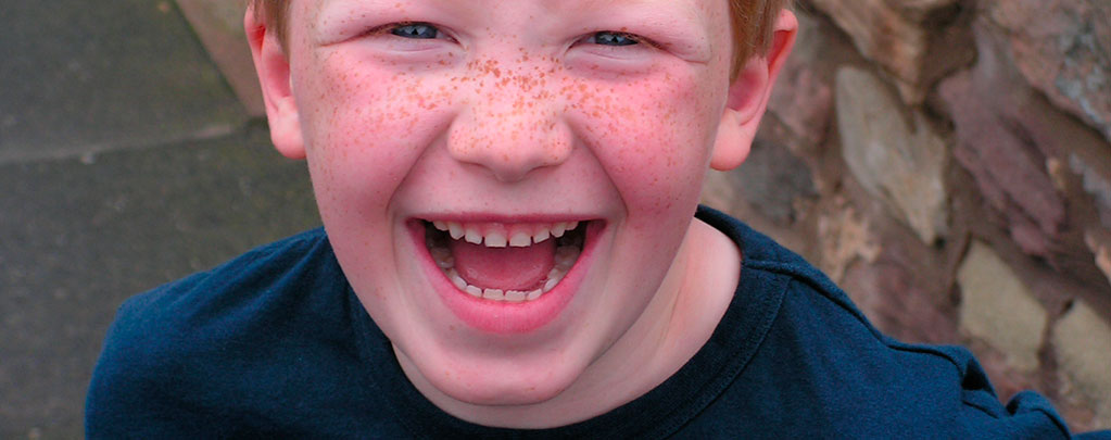 Niño sonriendo, despues de una broma con la app de Fart sound